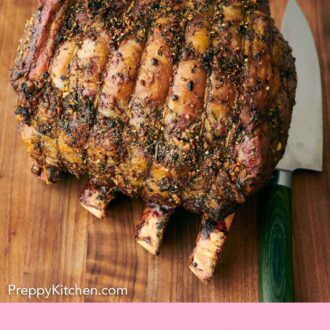 Pinterest graphic of a prime rib on a wooden cutting board with a knife beside it.