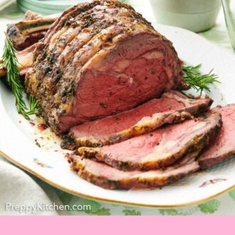Pinterest graphic of a platter of a semi-sliced prime rib with fresh rosemary on the side.