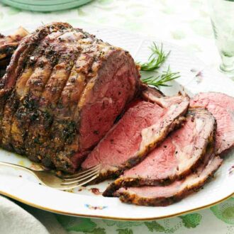 A platter of a semi-sliced prime rib with a fork on the side.