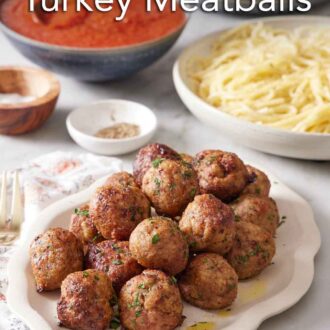 Pinterest graphic of a platter of air fryer turkey meatballs with sauce and noodles in the background.