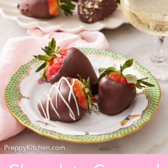 Pinterest graphic of a plate with three chocolate covered strawberries with a bubbly drink in the back.