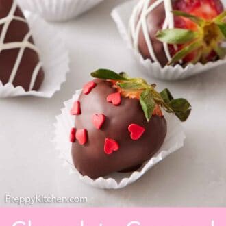 Pinterest graphic of chocolate covered strawberries in paper liners, some with heart sprinkles and some with white chocolate drizzle.