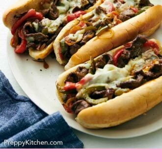 Pinterest graphic of a platter of three Philly cheesesteak with drinks in the background.