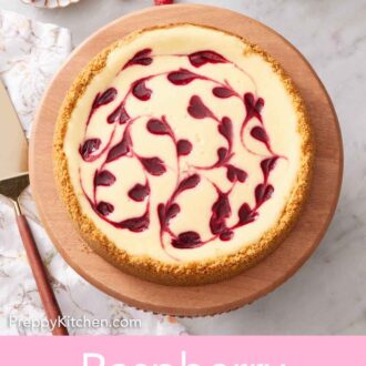 Pinterest graphic of an overhead view of a raspberry cheesecake on a wooden cake stand. A bowl of raspberries and mug of tea in the back.