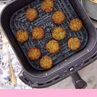 Pinterest graphic of an overhead view of an air fryer basket with eleven air fryer falafel.