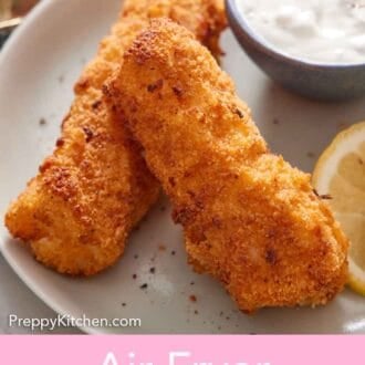 Pinterest graphic of two air fryer fish sticks on a plate with a bowl of tartar sauce.