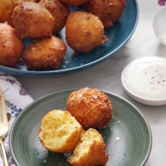 Pinterest graphic of a green plate with two hush puppies, with one torn in half. A large plate of more hush puppies in the background.
