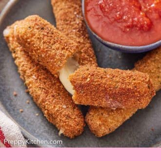 Pinterest graphic of a plate with mozzarella sticks, one torn opened, with a bowl of marinara sauce.