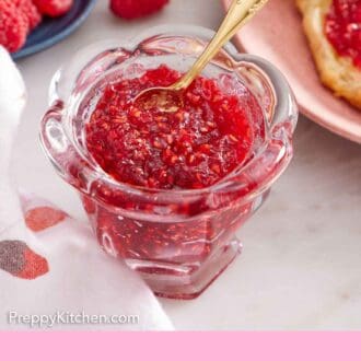 Pinterest graphic of a jar of raspberry jam with a small gold spoon inside.