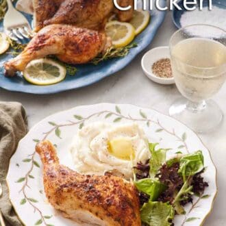 Pinterest graphic of a plate with a chicken leg, mixed greens, and mashed potatoes with the rest of the spatchcock chicken in the background on a platter with a drink.