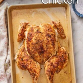 Pinterest graphic of a spatchcock chicken with crispy skin on a sheet pan.