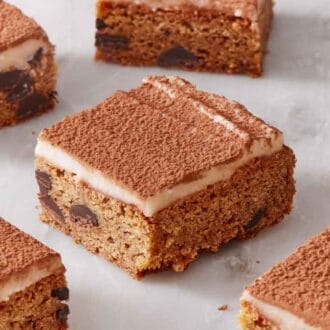 Multiple pieces of tiramisu blondies in a single layer on a marble surface.