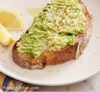 Pinterest graphic of avocado toast on a plate with two lemon wedges on the side.