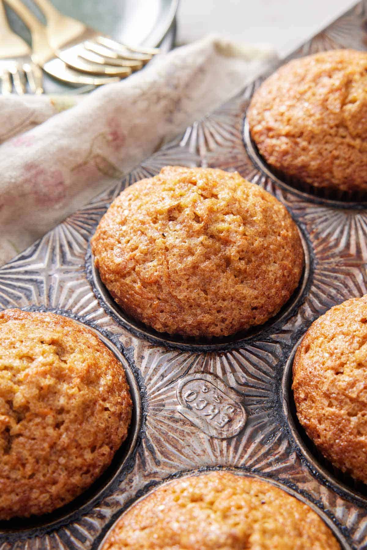 Multiple carrot muffins in the muffin tin.