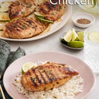 Pinterest graphic of a cilantro lime chicken breast over a bed of rice and a lime wedge on a plate. A platter with more chicken in the background with limes and a drink.
