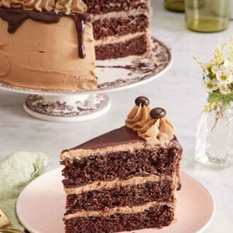 Pinterest graphic of a slice of moist mocha cake on a plate with the rest of the cake on a cake stand in the background.