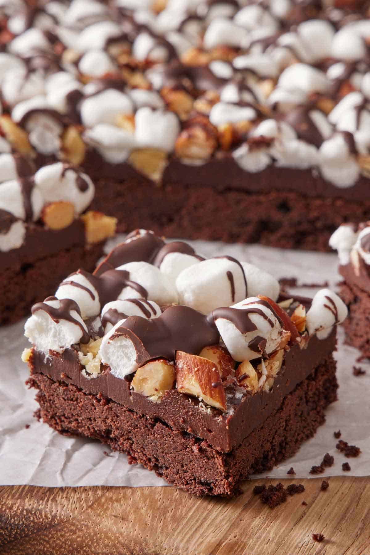 A close up view of a cut piece of rocky road bars with the rest of the slab in the background.