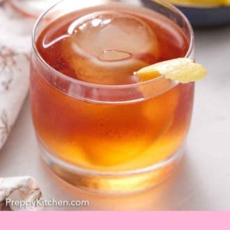 Pinterest graphic of a glass of Vieux Carré with one ice cube with a lemon peel garnish.