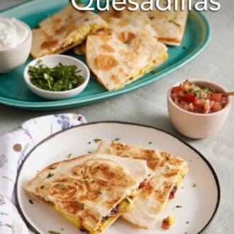 Pinterest graphic of a plate with two pieces of breakfast quesadillas. A platter in the background with more with bowls of sour cream and chopped cilantro.