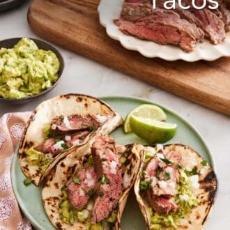 Pinterest graphic showing three carne asada tacos on a plate. Guacamole and sliced grilled meat on the side.