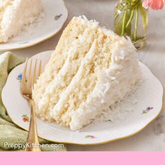 Pinterest graphic of a slice of coconut cake on its side on a plate showing the three layers with a fork beside it. A vase of flowers and more cake in the background.