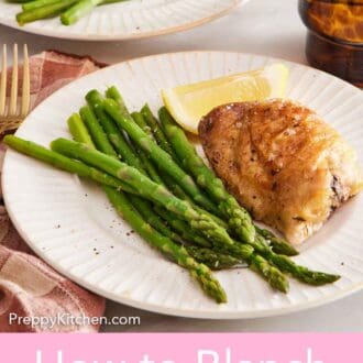 Pinterest graphic of a plate with blanched asparagus, crispy chicken thighs, and a lemon wedge.