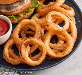 Pinterest graphic of a plate of onion rings with a small bowl of ketchup and burger.