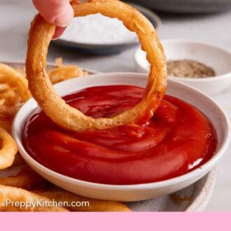 Pinterest graphic of an onion ring dipped into a bowl of ketchup.