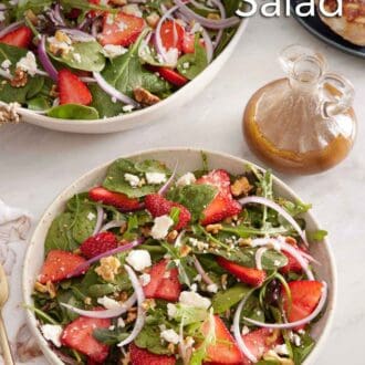 Pinterest graphic of bowl of strawberry salad with a platter more in the background along with a jar of salad dressing and a chicken breast.