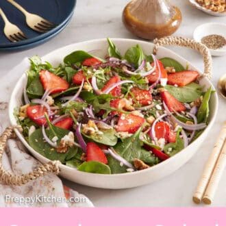 Pinterest graphic of a platter of strawberry salad. Glasses, salad dressing, flowers, plates, and forks in the background.