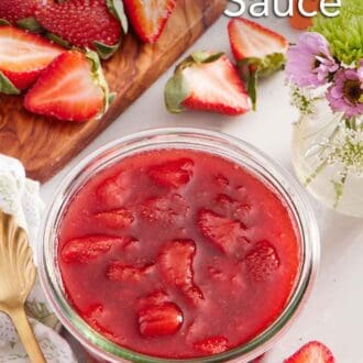 Pinterest graphic of a jar of strawberry sauce. Cut strawberries scattered around and on a cutting board along with a vase of flowers.
