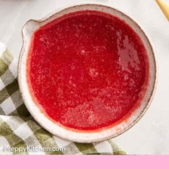 Pinterest graphic of a bowl of strawberry syrup. A strawberry, napkin, and spoon on the side.