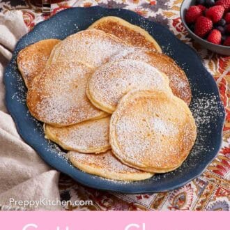 Pinterest graphic showing a serving platter containing pancakes dusted with powdered sugar, with mixed berries in a bowl on the side.