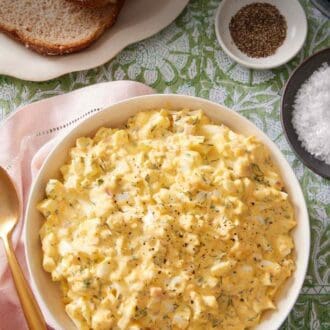 Pinterest graphic showing salad made of eggs, mayo, and herbs in a large serving bowl.