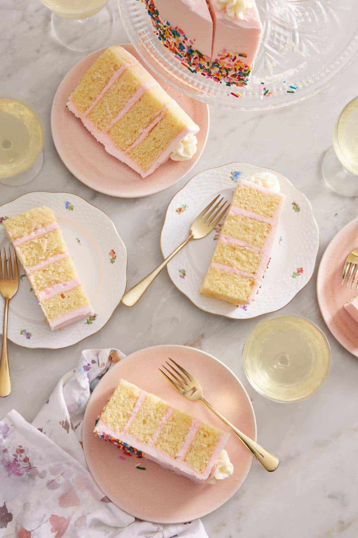 Slices of a layer cake on serving plates with forks.