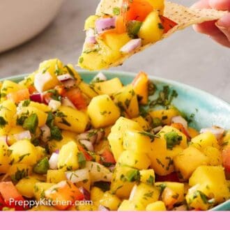 Pinterest graphic showing mango salsa scooped onto a chip.