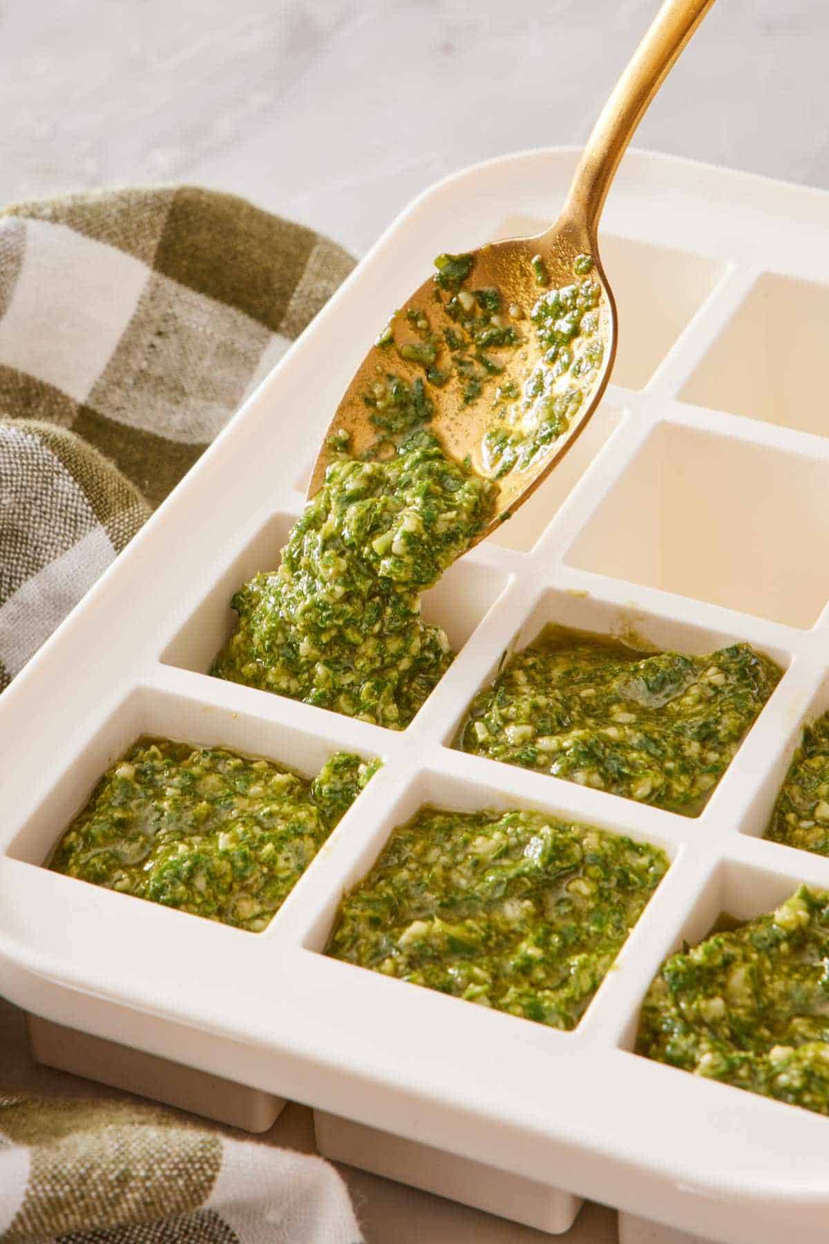 Freezing homemade pesto in an ice cube tray.
