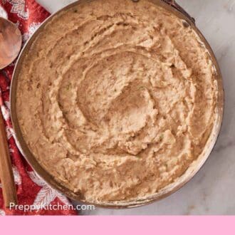 Pinterest graphic showing an overhead shot of homemade Mexican beans in a large skillet.
