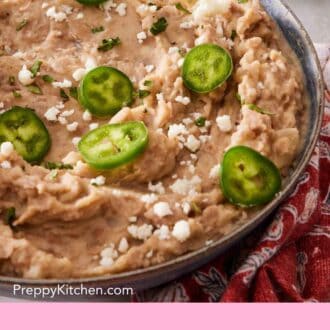 Pinterest graphic showing a close-up of refried beans with jalapeno slices and queso fresco on top.