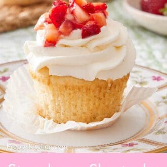 Pinterest graphic showing a close-up of a strawberry shortcake cupcake with whipped topping and diced strawberries.