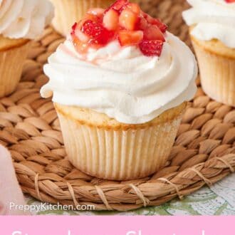 Pinterest graphic showing strawberry shortcake cupcakes on a woven serving board.