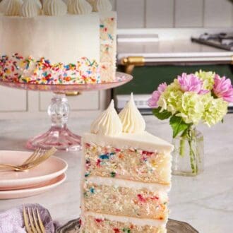 Pinterest graphic showing a slice of sprinkle cake on a plate with the rest of the cake in the background.