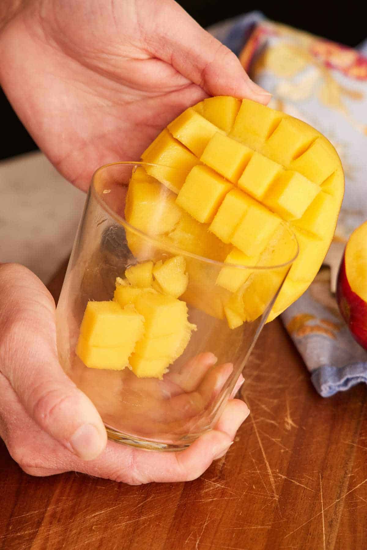 Image showing how to cut a mango using a glass.