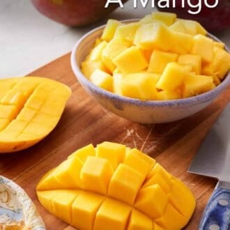 Pinterest graphic showing cubed mango in a bowl with mango cheeks with the flesh still attached to the skin in the foreground.