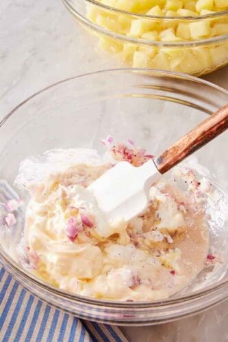 Creamy mayonnaise-based dressing stirred together with a spatula.