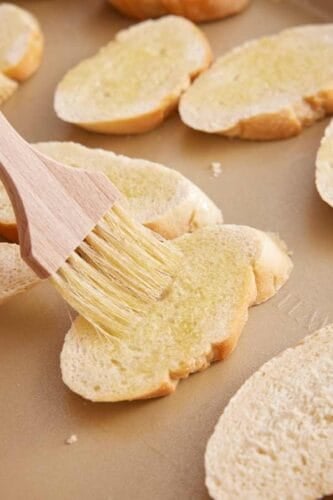 Olive oil brushed onto sliced bread.