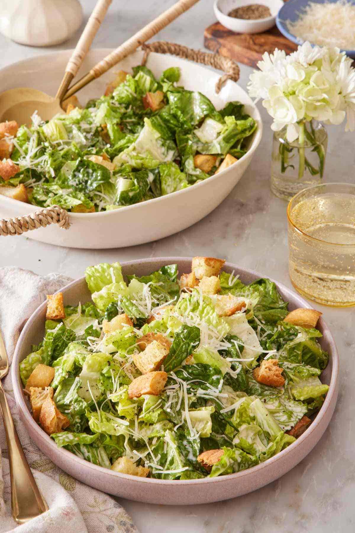 A plate of Caesar Salad with the serving bowl in the background.