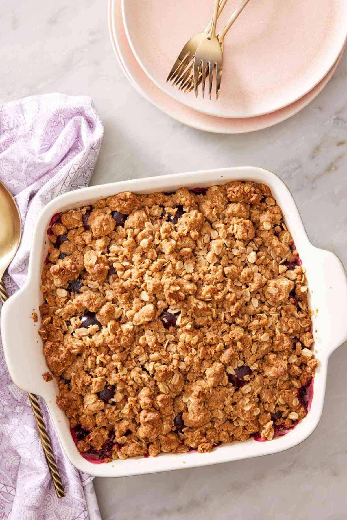 A square ceramic casserole dish containing cherry crisp.