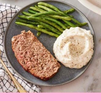 Pinterest graphic showing an overhead shot of meatloaf on a plate with two side dishes.