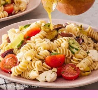 Pin image showing dressing poured over a plate of rotini salad.